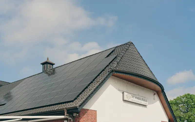 Instalacje fotowoltaiczne: panele fotowoltaiczne na dachu domu, w słoneczny dzień